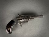 an old revolver with a wooden handle on a gray surface