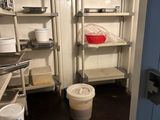 une pièce avec des étagères, un seau et une poubelle