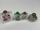 three small glass bottles with different designs on them on a white surface