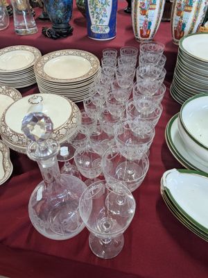 many plates and glasses on a table with a red table cloth
