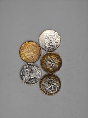 four different types of coins sitting on top of a white surface