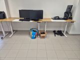 a computer desk with two monitors and a bag on the floor