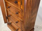 a small wooden chest of drawers with a mirror on top