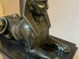 bronze statue of a sphinx on a marble base
