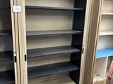 a metal cabinet with shelves and a laptop on the floor
