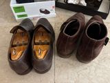 two pairs of shoes that are on the floor next to a shoe box