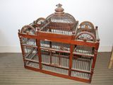 une cage à oiseaux en bois contenant deux oiseaux