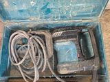 une boîte bleue contenant une perceuse et un cordon