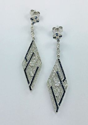 une paire de boucles d'oreilles en diamants et saphirs sur fond blanc