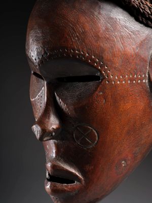 gros plan d'un masque en bois sur fond noir