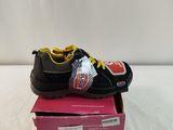 black and yellow shoes on top of a pink box on a white surface