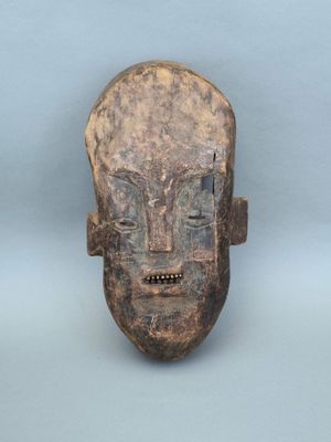 une image représentant un masque en bois sur fond bleu