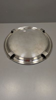 un plat en argent posé sur une table, muni d'une poignée