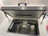 an open dishwasher sitting on a counter in a kitchen