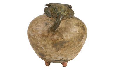 un vase marron surmonté d'une grenouille