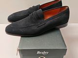 mocassins en daim noir pour homme, posés sur une boîte
