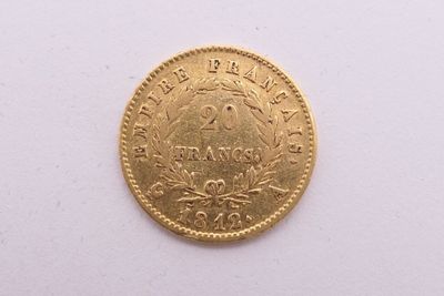 gros plan d'une pièce d'or sur une surface blanche