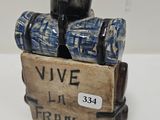 a small figurine of a suitcase with a wine glass in it