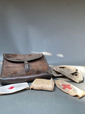 un étui en cuir marron posé sur une table, à côté d'une paire de gants
