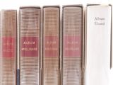 books are lined up in a row on a shelf next to a book case