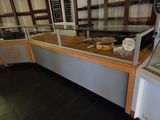 a display case in the middle of a store filled with different types of food