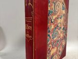 un vieux livre à la couverture rouge posé sur une table