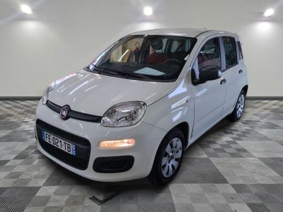 la petite voiture blanche est garée sur un carrelage à carreaux
