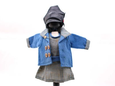 une poupée qui porte une veste et une robe bleues