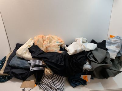 a pile of clothes sitting on a counter in front of a mirror