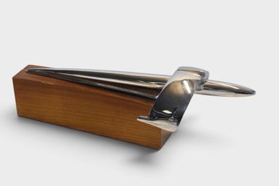 a wooden block with a pair of tonges on it