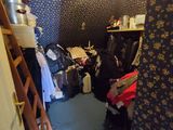 une pièce avec une échelle et une armoire remplie de vêtements