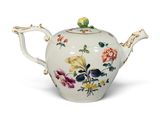 une théière blanche ornée de fleurs, posée sur un fond blanc