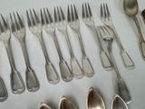 many spoons and forks laid out on a table