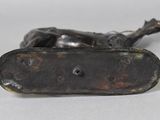 an image of a bronze statue of a dog laying on its back