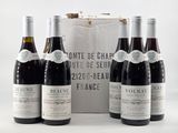 six bottles of wine are lined up in front of a white box