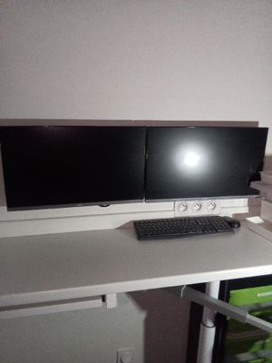 un bureau d'ordinateur équipé de deux écrans et d'un clavier