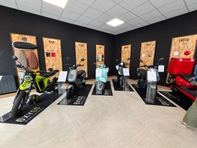 de nombreux scooters exposés dans une pièce aux murs noirs
