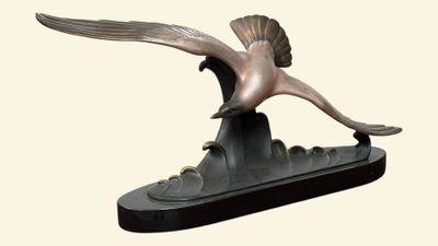 statue représentant un oiseau volant au-dessus d'un bateau sur fond blanc