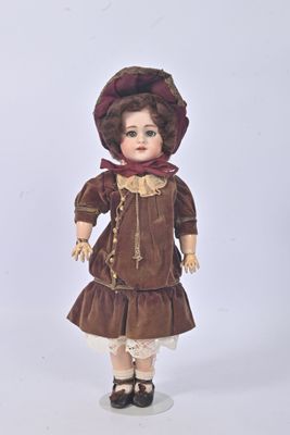 une poupée qui porte une robe marron et un chapeau