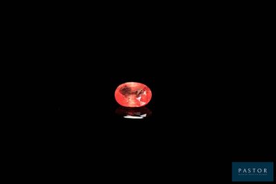 a close up of a red diamond on a black surface