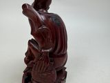 an image of a wooden statue of a man sitting on a lotus