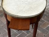 a small table with a marble top on a brick floor