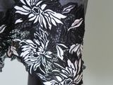 the back of a dress with black and white flowers on a mannequin