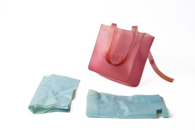 un sac rose et un sac bleu posés sur une surface blanche