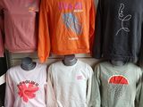 many different colored shirts on display in a store