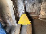 a man standing next to a fork lifter in a garage