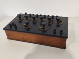 a close up of a wooden and black electronic device on a white surface