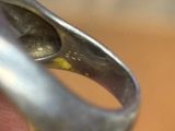 une bague en argent contenant une pierre jaune
