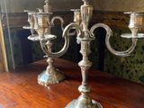 two silver candelabs sitting on a wooden table
