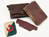 three pieces of leather and a wallet on a white surface